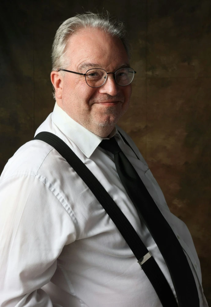 A man in a white shirt and black suspenders
